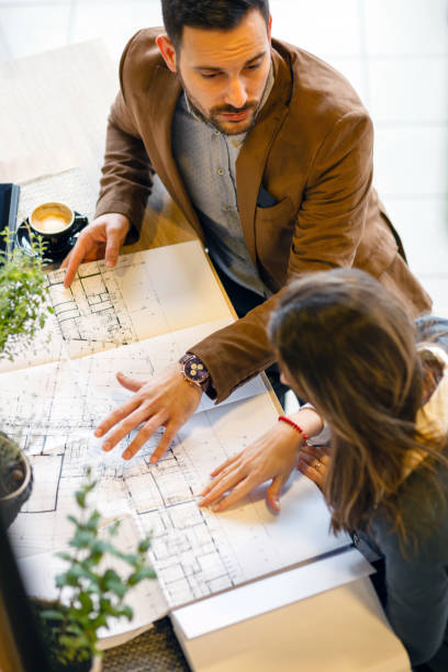 istock Two young architects discussing building plans during a meeting in a modern cafe 1187617779