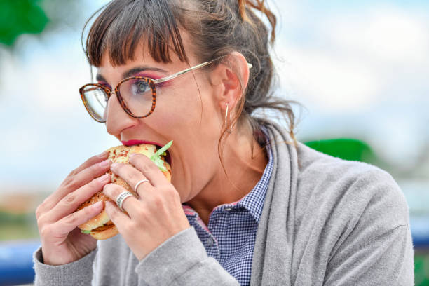 istock A woman eating a burger 1187619564