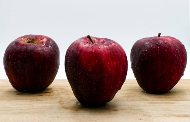 istock Red apples on wooden table, white background 1187620224