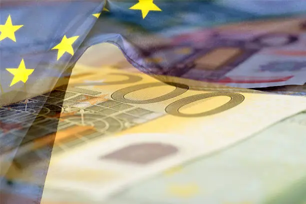 Photo of Flag of the European Union EU and Euro banknotes