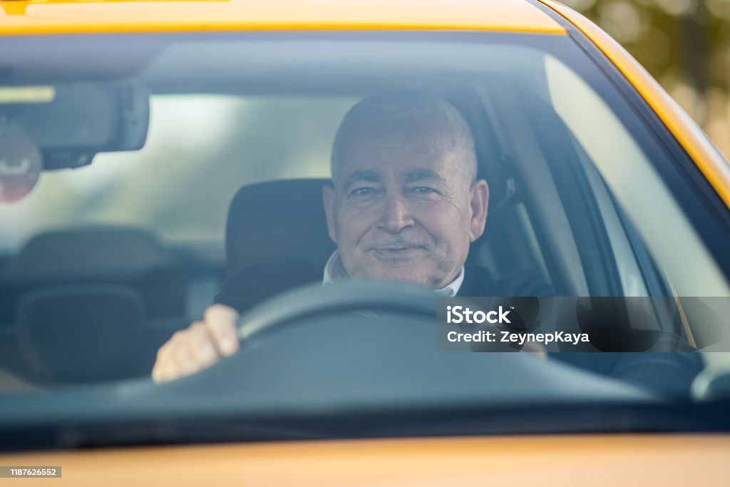 The Taxi Driver. Senior Taxi Driver looking to the camera. Taxi Driver Stock Photo