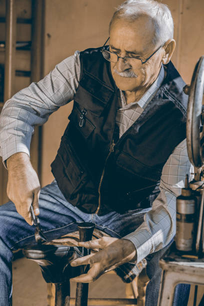 istock Senior adult male shoemaker working in workshop 1187629036