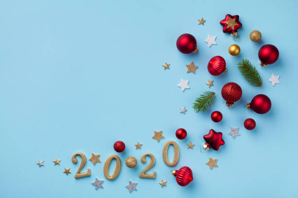 istock Creative flat lay composition with Christmas tree ornaments, numbers 2020 and holiday decorations on blue background top view. New Year greeting card. 1187629083