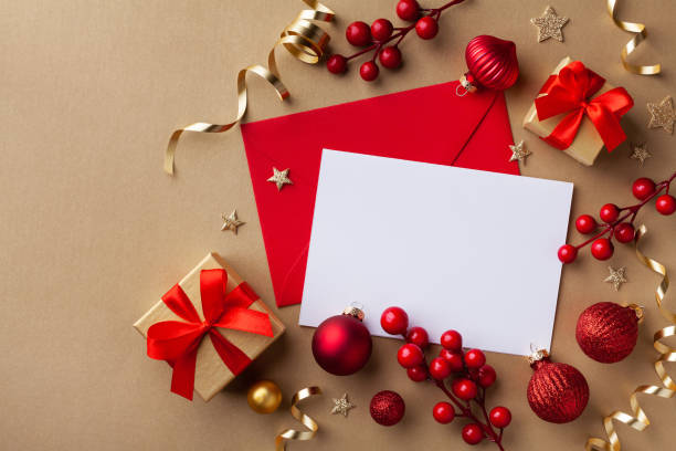 istock Empty paper blank for Christmas or New year greeting card. Gift boxes, holiday decorations on golden background top view. Flat lay style. 1187629309