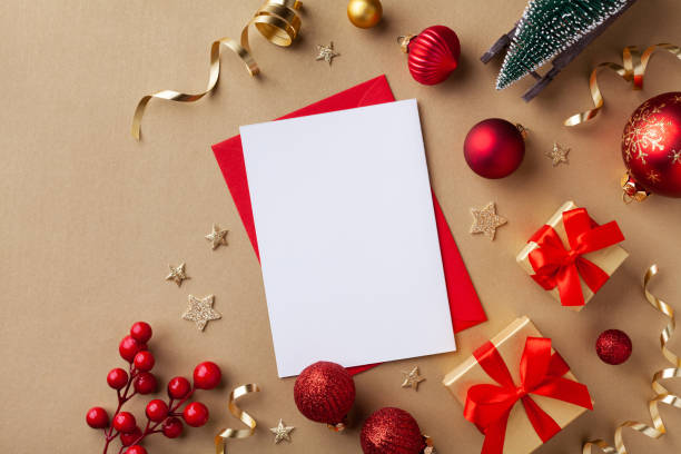 istock Empty paper blank for Christmas or New year greeting card. Gift boxes, holiday decorations, small fir tree on golden background top view. Flat lay. 1187629341