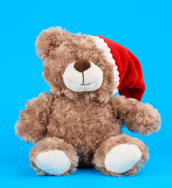 istock little cute brown teddy bear with in a red Christmas hat 1187630880