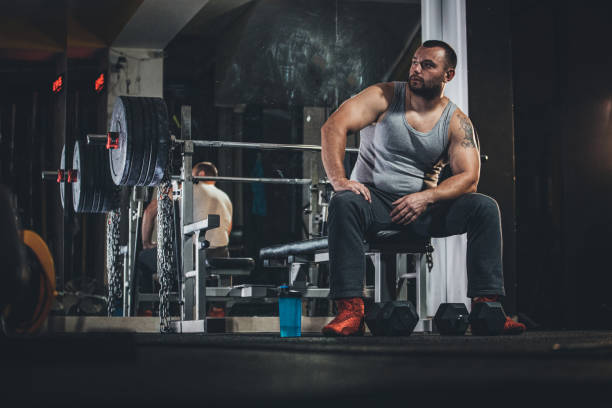 istock Strong guy sitting in gym 1187634923