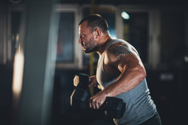 istock Man training in gym with dumbbells 1187635048