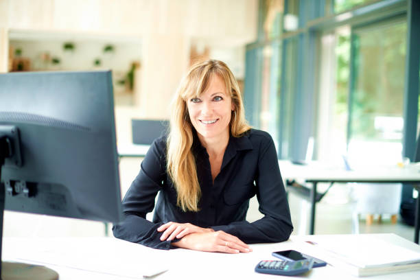 istock Businesswoman sitting at office desk behind her computer 1187636676