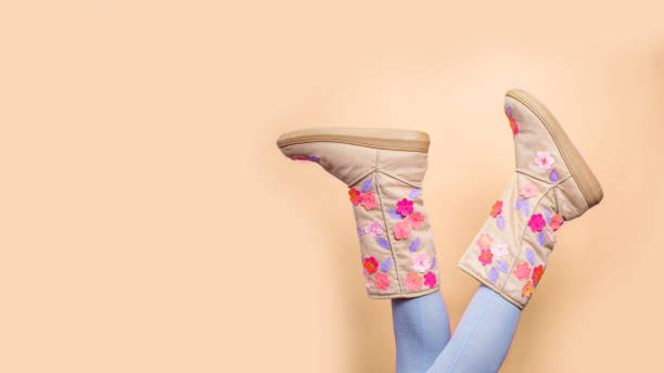 istock Funny winter female legs boots over pastel background 1187638649