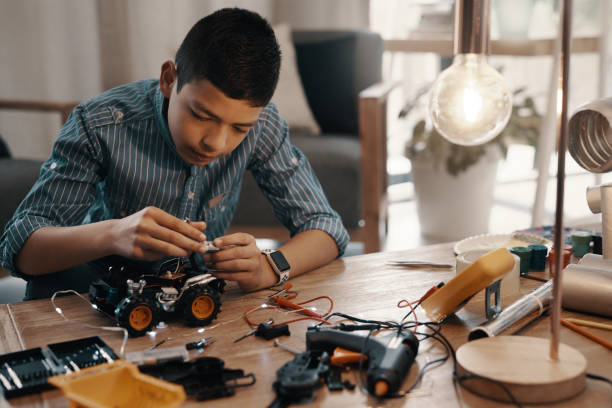 Shot of a handsome young boy building a robotic toy car at home