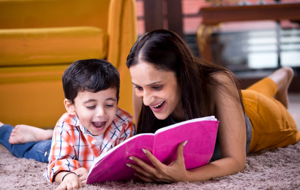 istock Astonished mother with son writing in book 1187639005