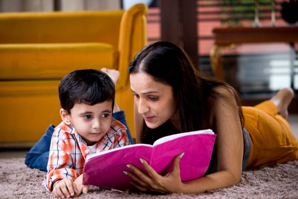 istock Astonished mother with son writing in book 1187639026