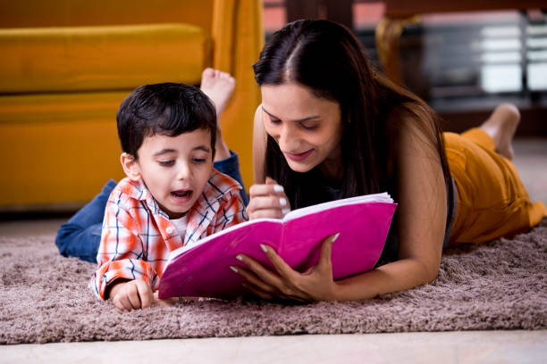 istock Astonished mother with son writing in book 1187639046