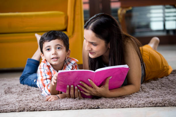 istock Astonished mother with son writing in book 1187639073