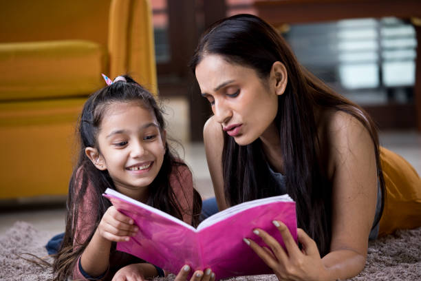 istock Mother with her daughter reading book at home 1187639109
