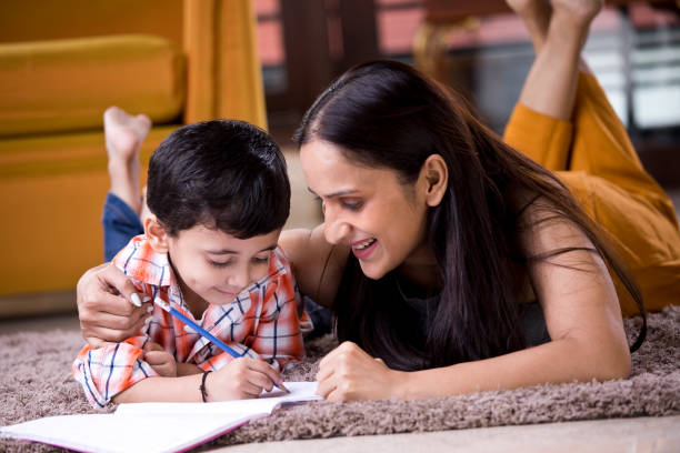 istock Astonished mother with son writing in book 1187639219