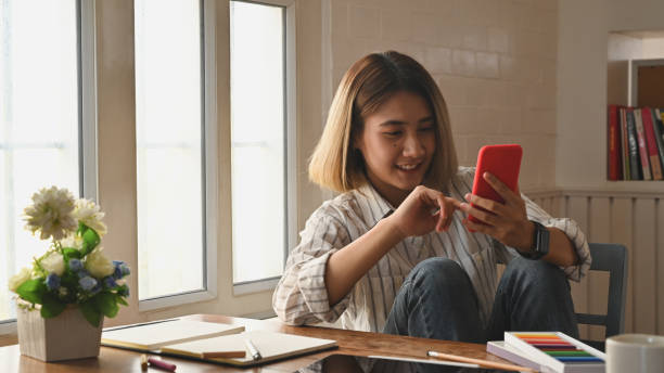 istock Young woman holding her smartphone on table with copy space. 1187639981
