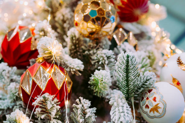 árvore de natal tradicional com decorações de veludo vermelho e geada branca nos pinhos. - bow christmas red velvet - fotografias e filmes do acervo