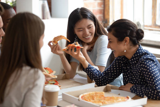 istock Multicultural students best friends gathered together eating pizza 1187643063