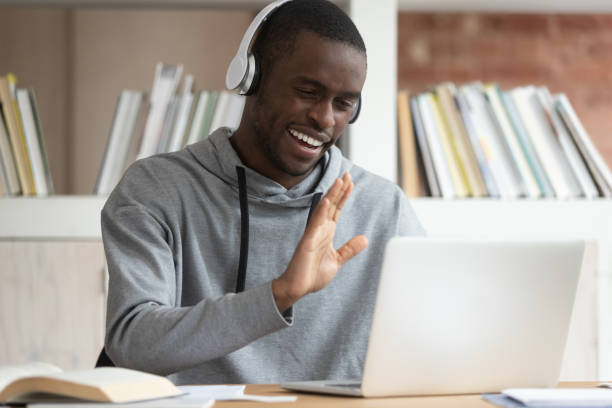 istock African guy in headphones makes videocall greeting online tutor 1187643132