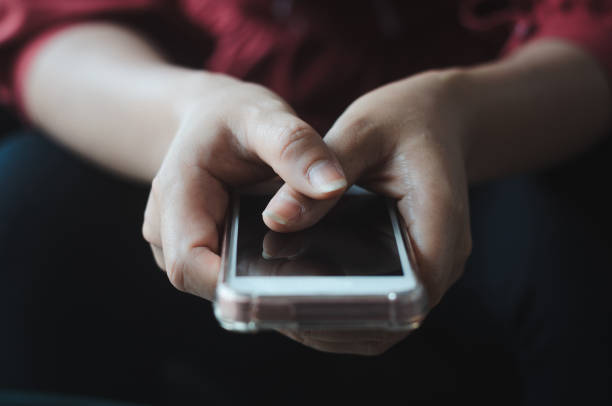 istock hipster woman using hands touching and typing on mobile phone screen search internet online working or social communication with digital 5G technology app device in coffee shop indoor lifestyle. 1187647664