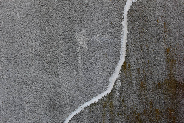 Concrete wall with crack repaired with white concrete patching putty