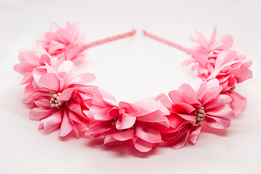 Baby hair accessory with pink flowers on white background