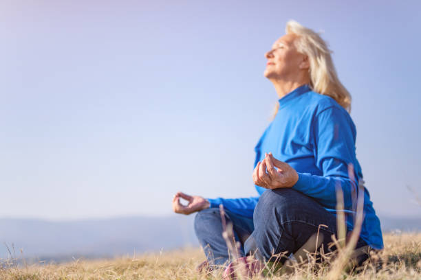 istock Senior woman meditating in nature. 1187652112