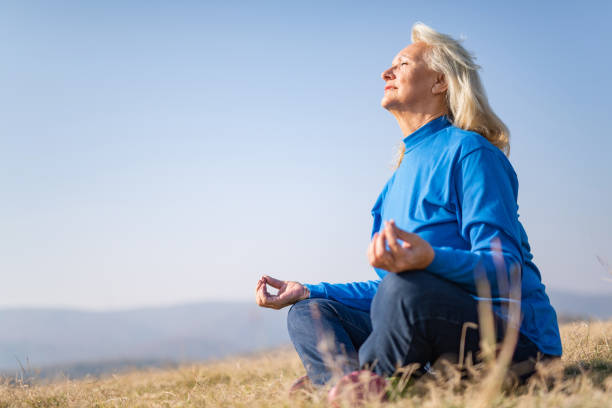 istock Senior woman meditating in nature. 1187652133