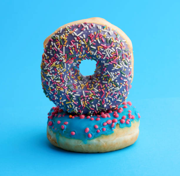 istock two round baked donut with colored sugar sprinkles and with blue sugar icing 1187652302