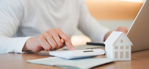 cerrar joven prensa mano en calculadora para comprobar y sumario gasto de hipoteca de préstamo de vivienda para plan de refinanciación, concepto de estilo de vida de las personas - save costs fotografías e imágenes de stock