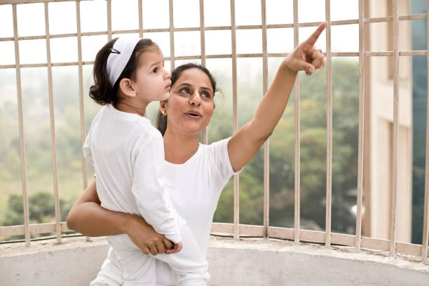 istock Mother pointing and showing something to daughter 1187653454