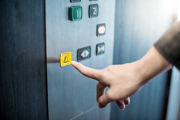 Male hand pressing on emergency button in elevator Male forefinger pressing on emergency stop and alarm button in elevator (lift). Mechanical engineering concept hand elevator stock pictures, royalty-free photos & images