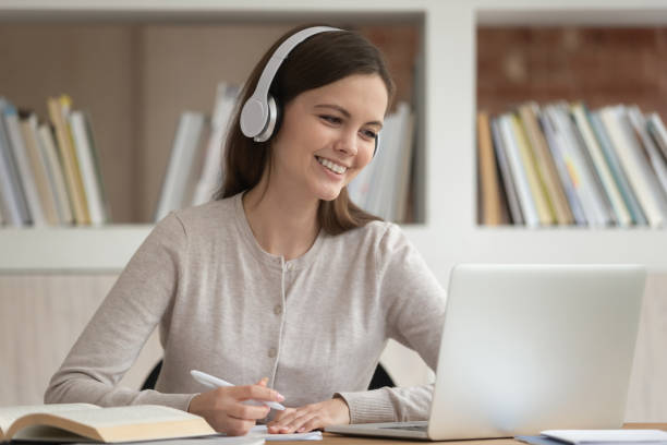 girl in headphones look at pc screen noting studying indoors - ready for text audio imagens e fotografias de stock