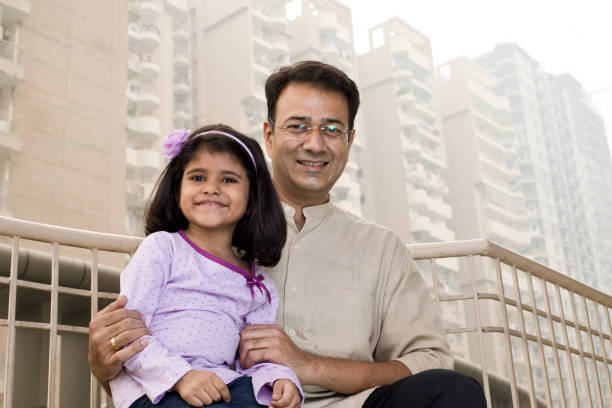 istock Happy father and daughter sitting at balcony 1187658699