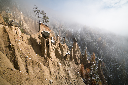 Winter view of the Earth Pyramids of Perca on a misty day. Perca, South Tyrol, Italy