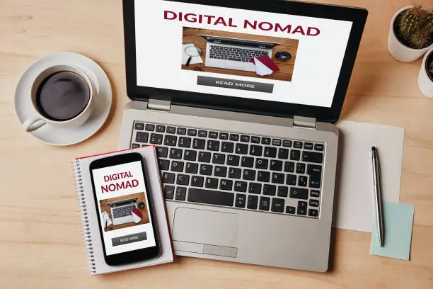 Digital nomad concept on laptop and smartphone screen over wooden table. Top view