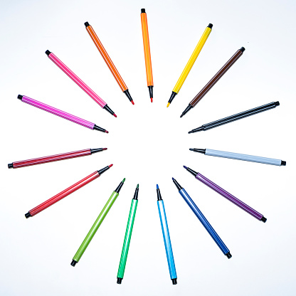 Bright multi-colored felt-tip pens on a white background. Felt pens are laid out in a pattern. Copy space, isolated