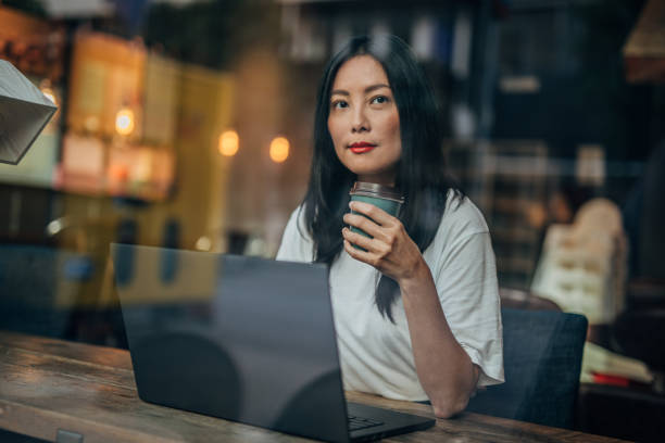 istock Woman drinking coffee and using laptop 1187667197