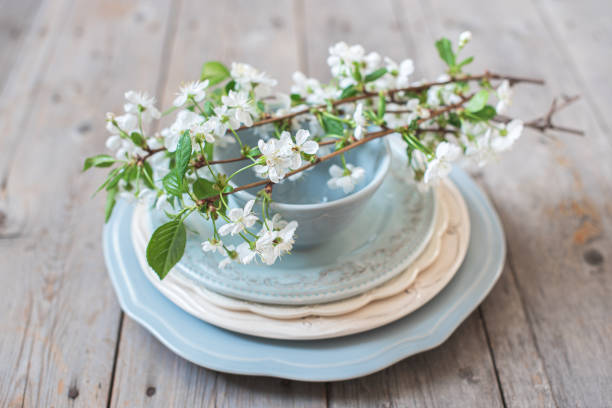 istock Branches of white cherry blossoms on a stack of blue plates 1187667824