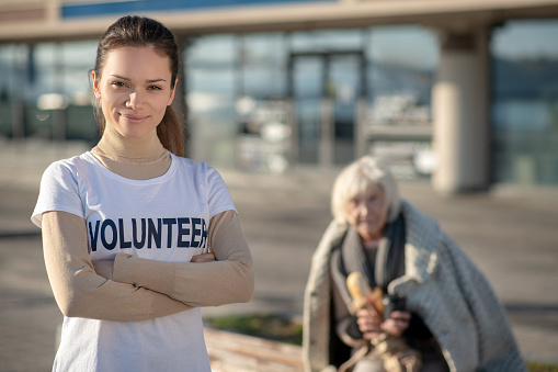Feeling motivated. Dark-eyed volunteer wearing white shirt feeling motivated while helping homeless