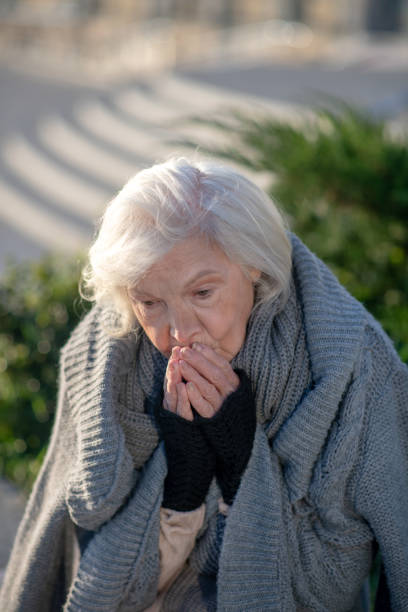istock Grey-haired homeless pensioner feeling very cold outside 1187668148