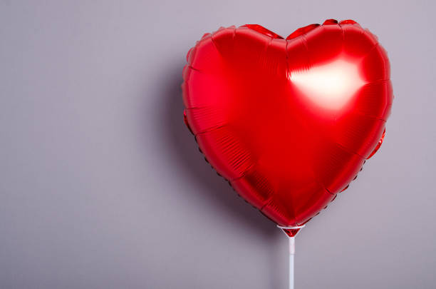 istock Red balloon shaped heart on gray background 1187668491