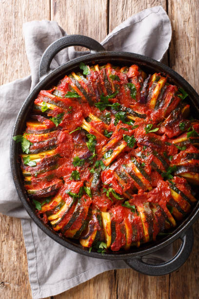 istock Vegetarian baked vegetable mix in tomato sauce close-up. Vertical top view 1187669802