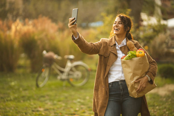 istock Woman with groceries bag making a selfie 1187671254