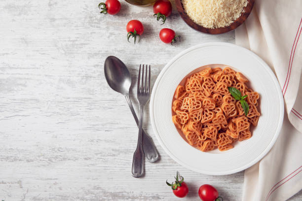 herzförmige pasta - tomato soup red basil table stock-fotos und bilder