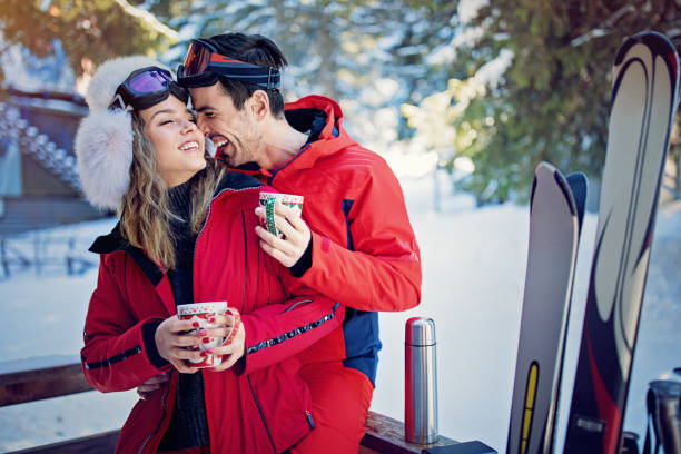 istock Young couple is hugging and drinking hot tea after skiing 1187674833