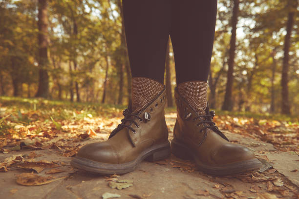 istock Women's legs standing in autumn leaves. 1187676123