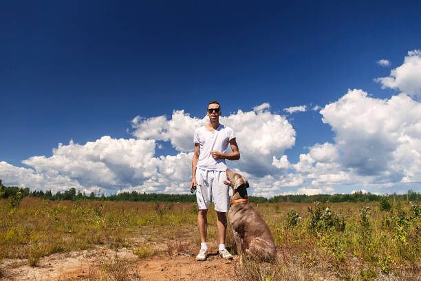istock Man playing with dog on nature at daytime 1187680322